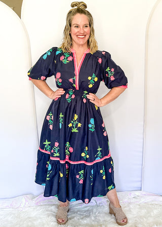 Colorful floral navy midi dress featuring pink contrast trim and a gathered waistline