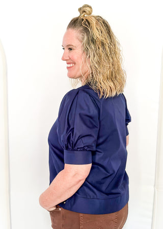 Navy v-neck blouse with puff sleeve.  Silver stud detail along hem, collar and down the front. 
