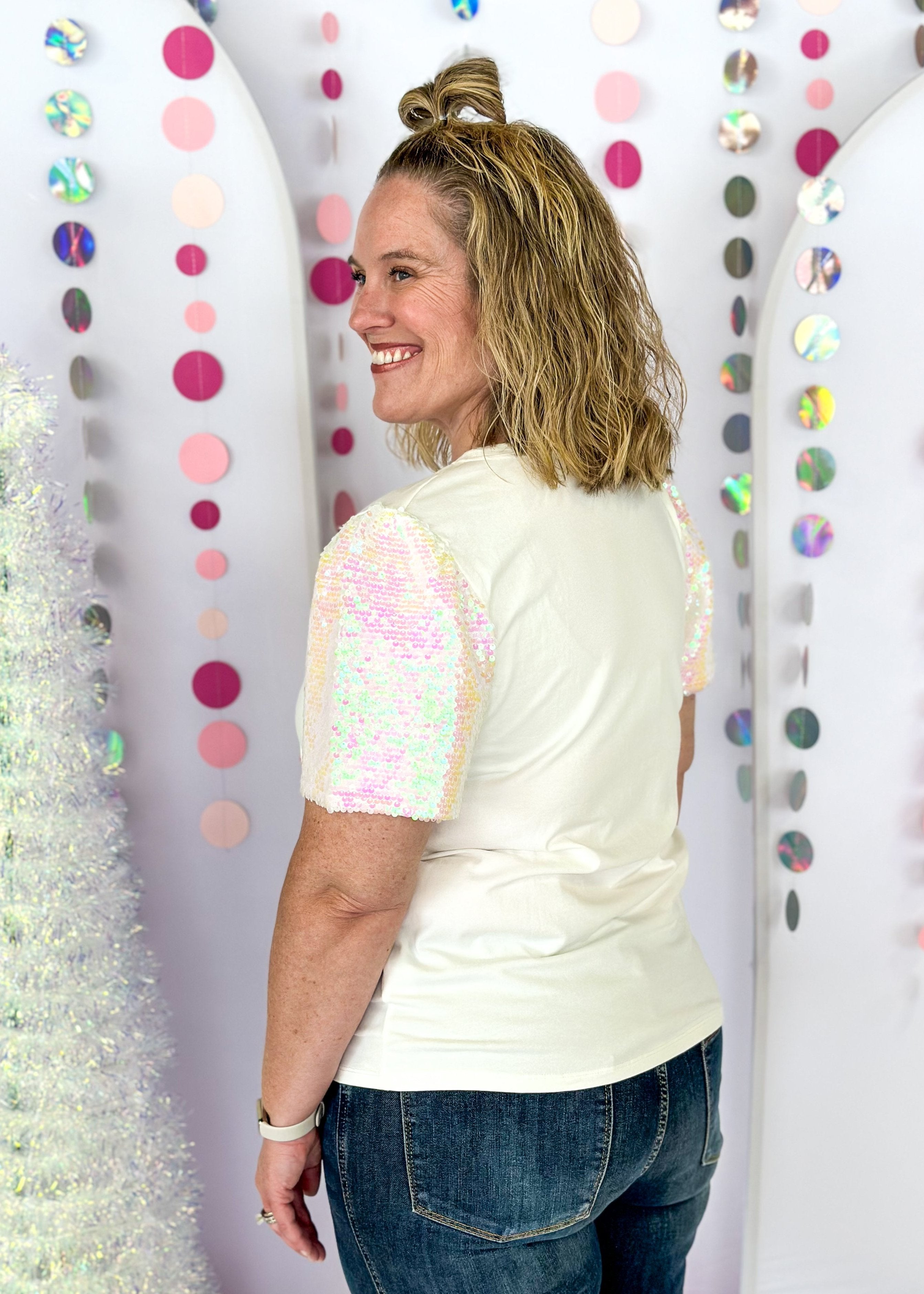 white short sleeve top with iridescent sequin sleeves, round neck, sparkly trio of trees patch on the front