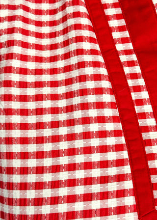 Close up of red gingham sleeveless dress with contrast trim neckline