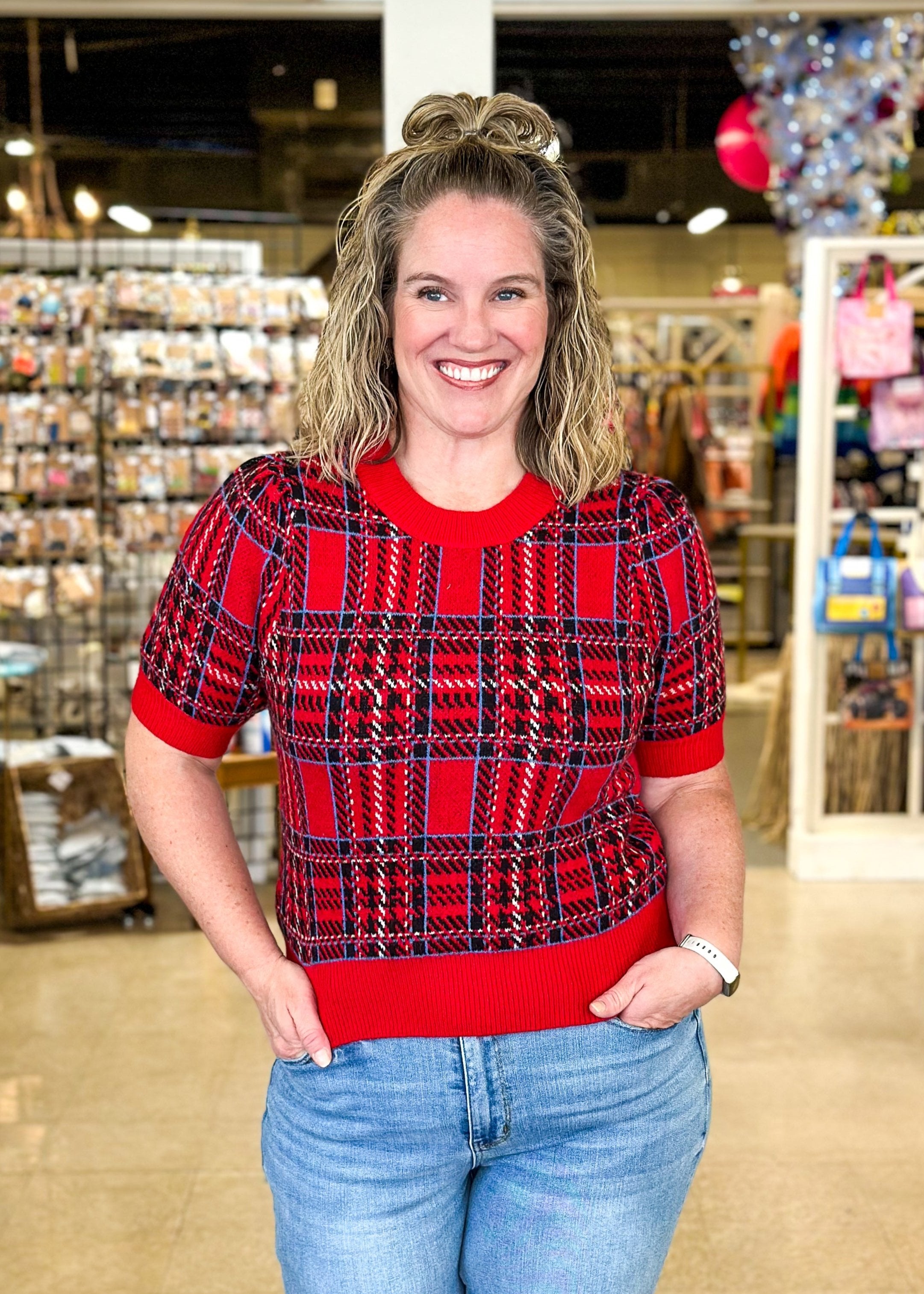 Red plaid short puff sleeve sweater with black and blue plaid and sold red bands around cuff, hem and neck