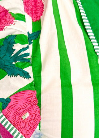 Close up of green and white striped midi dress with pink floral print, flutter sleeves, contrast V-neckline, and a flowy tiered hem