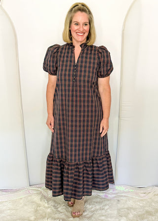 woman wearing a plaid midi dress with puff sleeves and a tiered ruffle hem