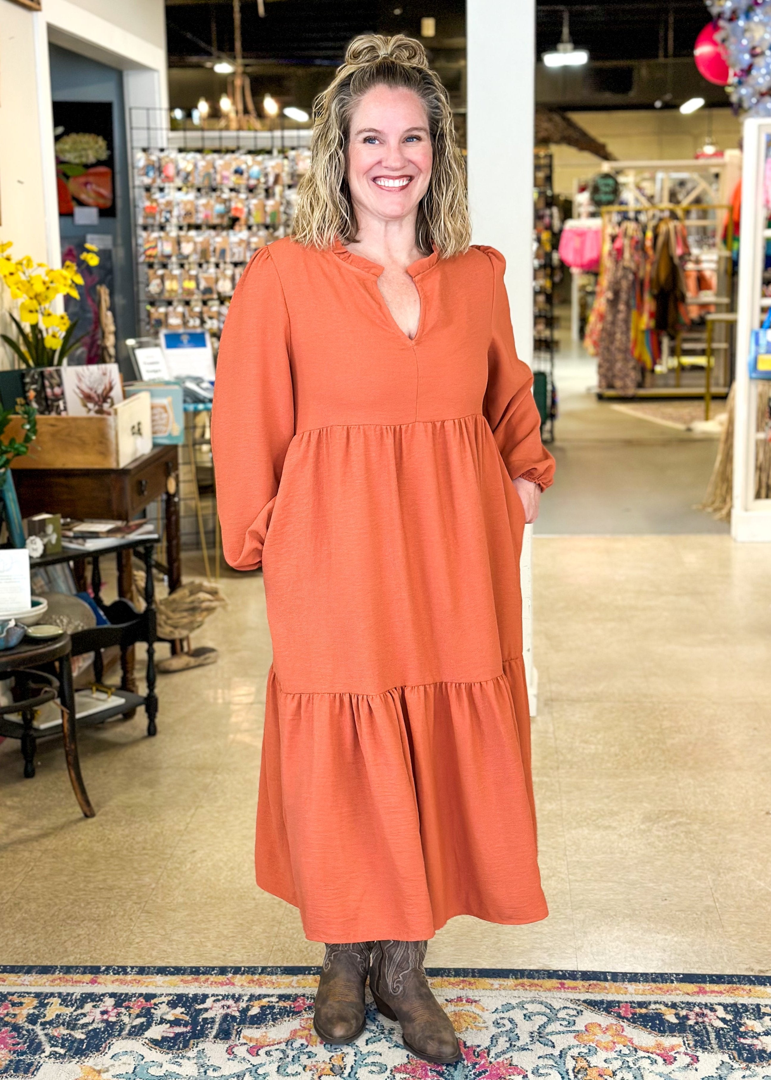 Long sleeve tiered midi dress with pockets, v-neck and ruffle around the neckline – color is pumpkin 