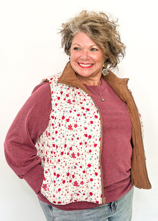 Reversible puffer vest with red and pink floral on one side, brown corduroy on the other.  Pockets on both sides, collared with zipper closure.