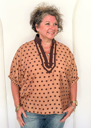 woman in camel dolman top with chocolate polka dots.
