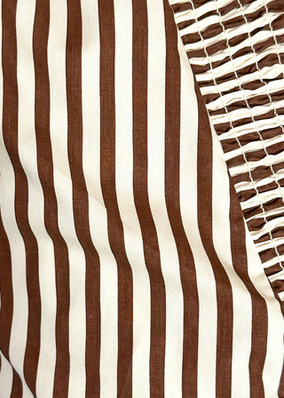 Close-up of a brown and off-white vertically striped fabric with a smocked mesh panel on the right side.