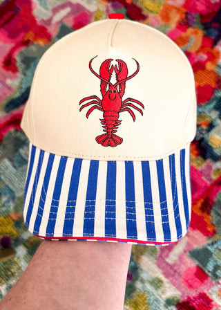Snap back ball cap with red crawfish and striped blue and white bill