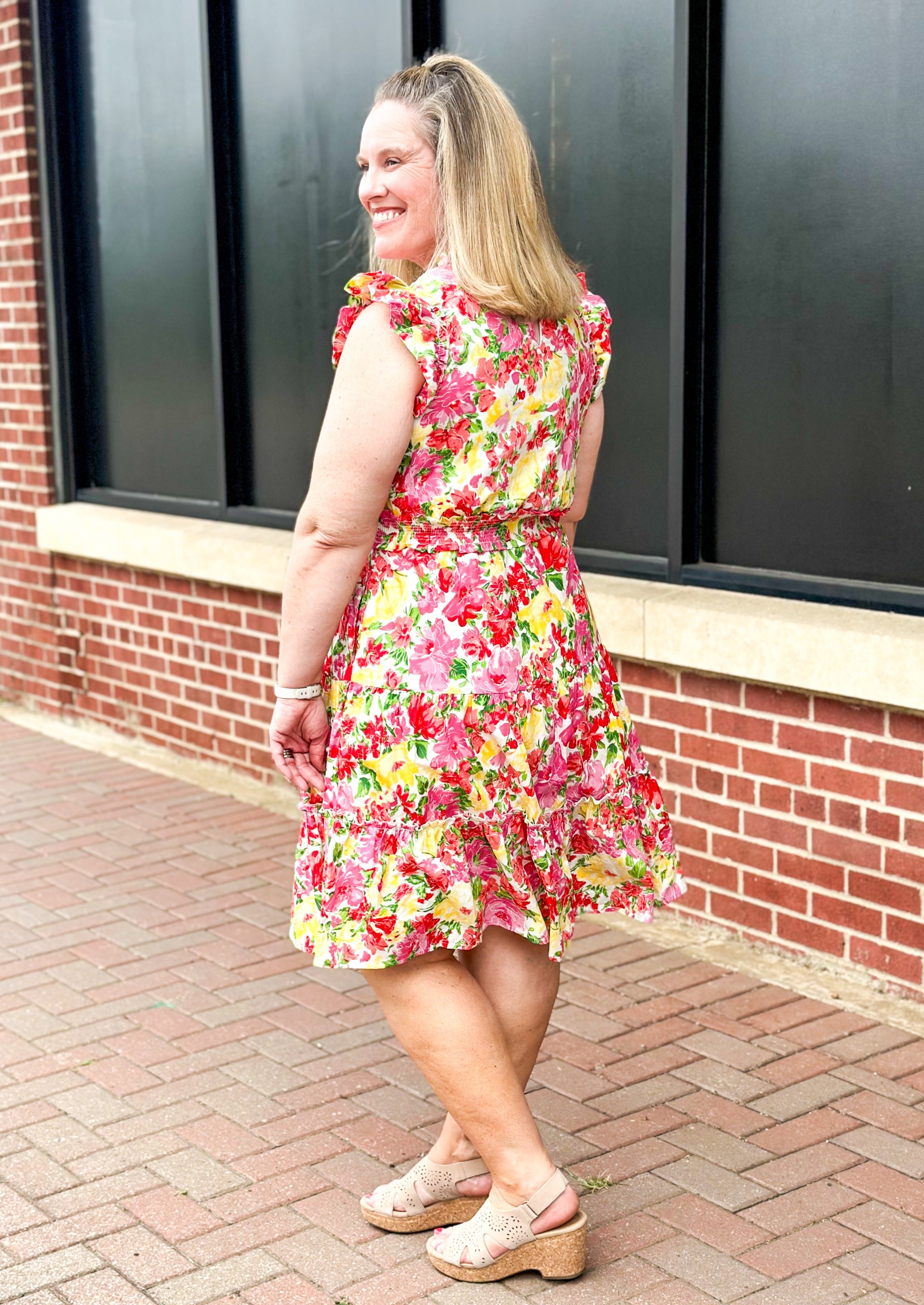 bright floral print smocked waist dress with pockets, ruffle sleeve and neck and one around the bottom  - print colors are yellow, pinks, reds and some green