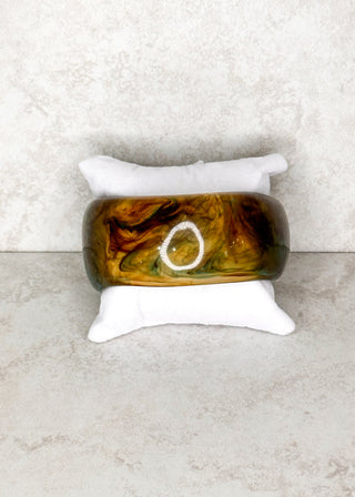 Olive and brown bangle bracelet displayed on a stand 
