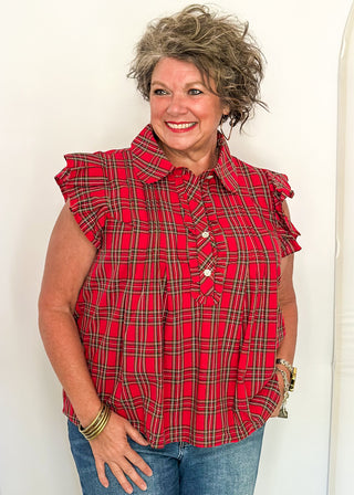 woman wearing red plaid shirt with flutter sleeves and rhinestone buttons.