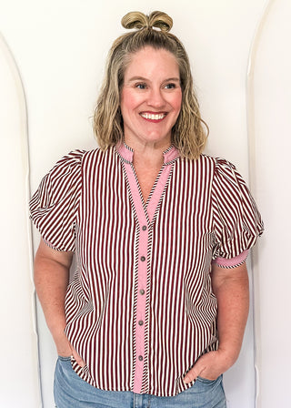 woman wearing burgundy stripe button up top 