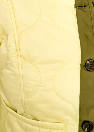Close up of light sage green quilted jacket with darker contrast trim, long sleeves, patch pockets, and button-front closure