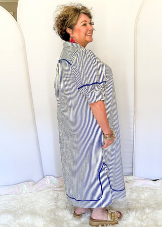 Blue and cream striped midi dress with short sleeves, split V-neckline with contrast trim, pockets, and a relaxed fit.