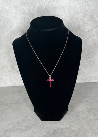 Black velvet jewelry display with a pink gemstone necklace on a gray concrete background
