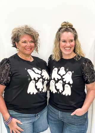 Black short sleeve top with sequin sleeves. Multiple white ghosts on the front