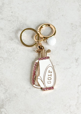 Keychain with golf club and ball design on a light gray background