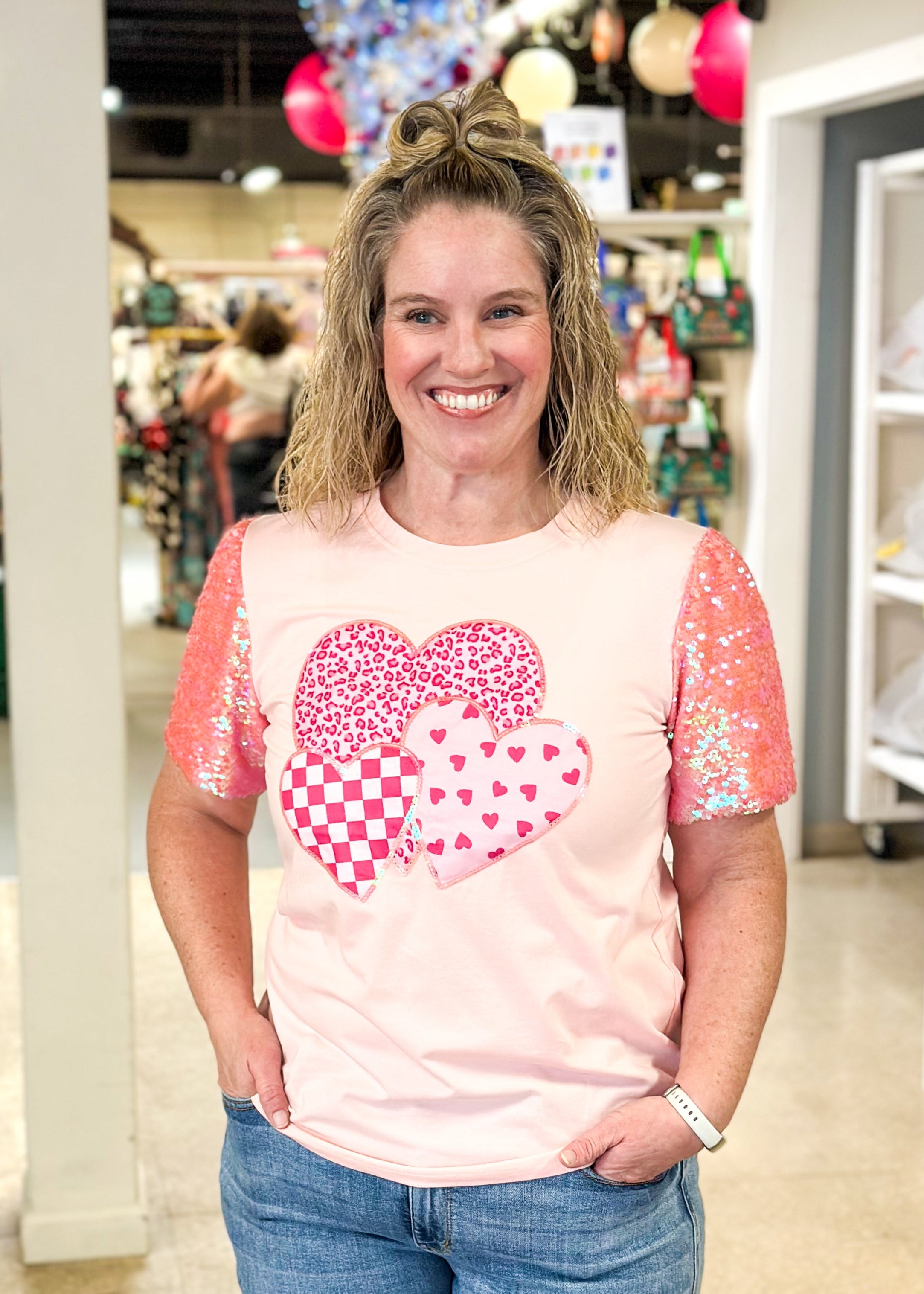 pink short sequin sleeve top with 3 hearts on the front outlined in sequins