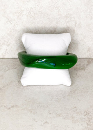 Green bangle bracelet displayed on a stand 
