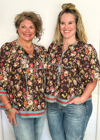 Fall floral Babydoll top with 3/4 puff sleeve, orange and blue strip detail on banding of hem and sleeve. blue ribbon detail on the front and tie at the collar. 