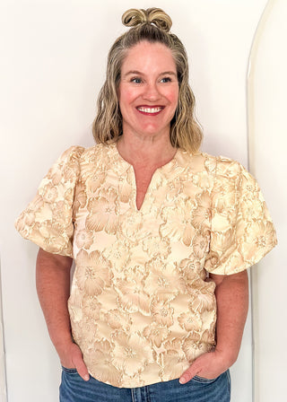 woman in jacquard floral puff sleeve top in champagne.