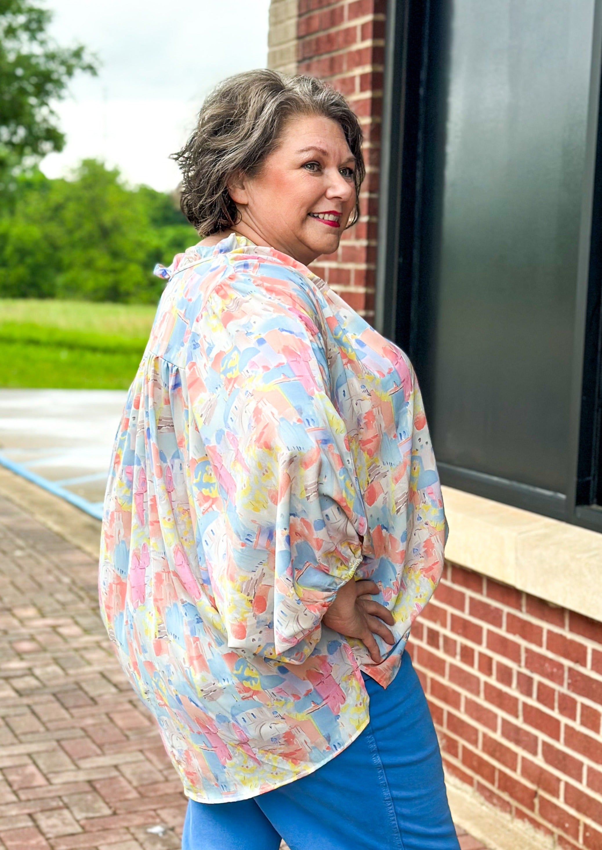 Pastel abstract print with building - v-neck with tie and ruffle - dolman 3/4 sleeve with elastic - lightweight