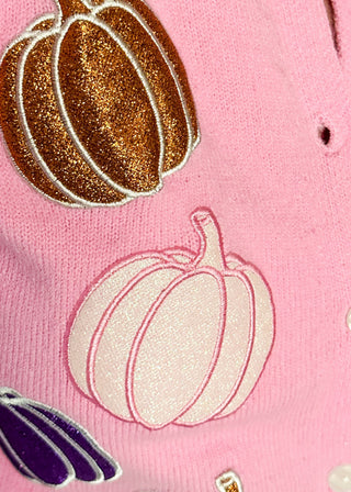 Close up of pink sweater and glitter pumpkin detail 