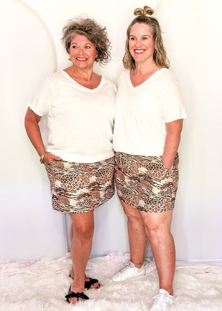 Two women wearing a skort with a wild animal print, featuring built-in shorts and pockets.