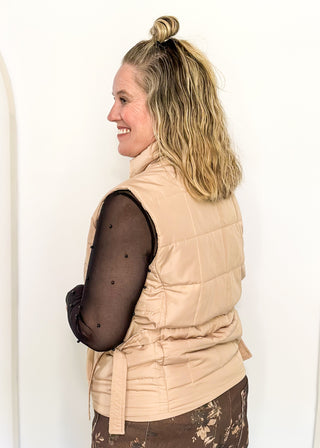 Beige puffer zip up vest with sides that tie and pockets