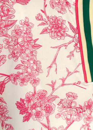 Close up of white top with pink floral pattern and v-neckline with contrast trim