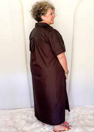 Casual black women’s dress with collared neckline, rolled sleeves, and decorative gold snaps