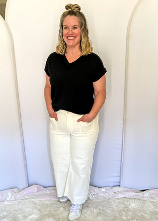 White wide crop Judy Blue jeans with double gold button closure, front patch pockets, high rise fit, and cropped wide leg silhouette with raw hem