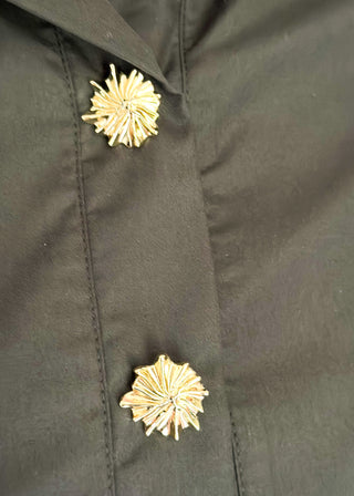 Collared black blouse with detailed gold snaps. short sleeve