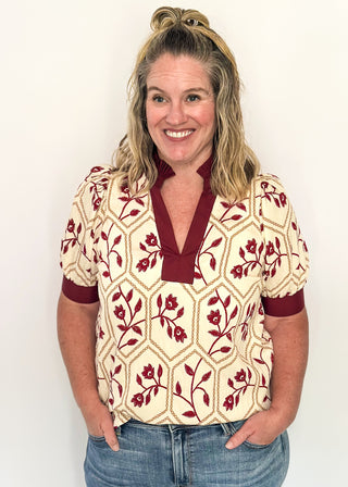 Neutral blouse featuring garnet florals with geometric hexagon pattern.