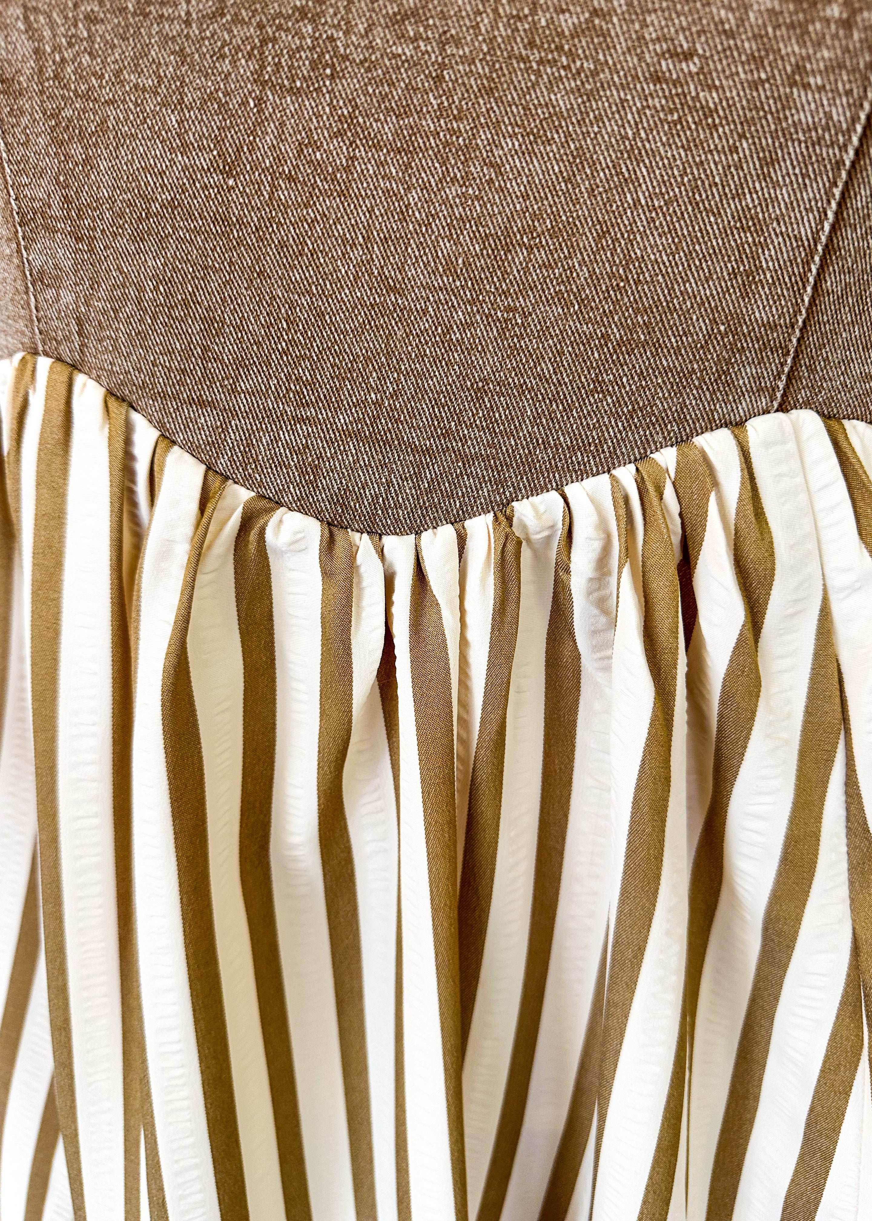 Maxi dress with pockets. brown vertical stripes on the bottom and brown denim overall top. Large front pocket and two buttons on either strap to adjust length.