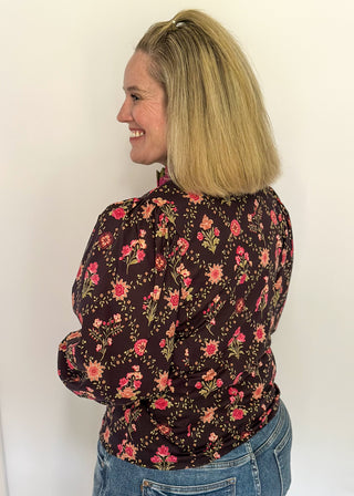 Deep navy floral ruffle trim long sleeve top with rich pink and olive accents.