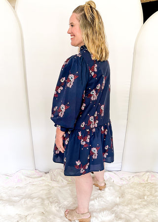 Floral navy dress featuring v-neckline, burgundy piping, and puff sleeves
