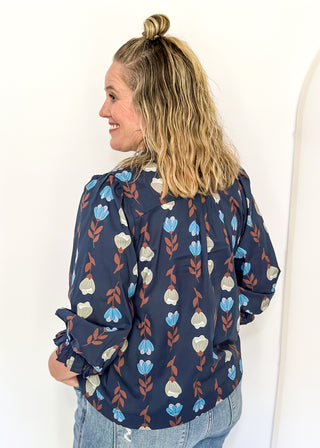 navy 3/4 length top with light blue and cream flowers and brown stems - light blue scalloped trim detail around v-neck