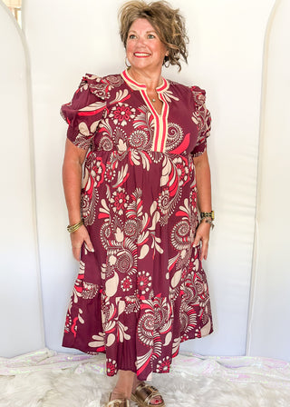 Plum floral maxi dress with short sleeves and v-neck. Collar has contrast piping in light brown and coral. 