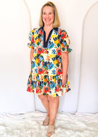 Vibrant watercolor floral dress with short sleeves, lined fabric, tiered hem, and pockets