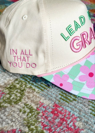 Side of snap back hat with "in all that you do" embroidered in pink