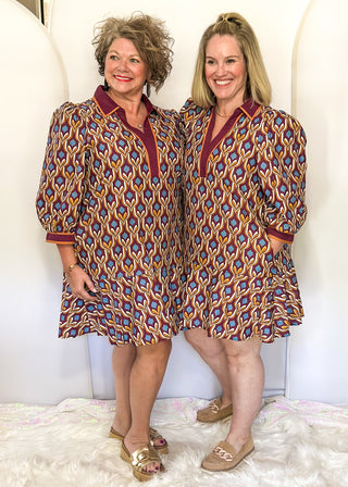 Wine-colored geometric print dress with collared neckline, tiered hem, and 3/4 sleeves.