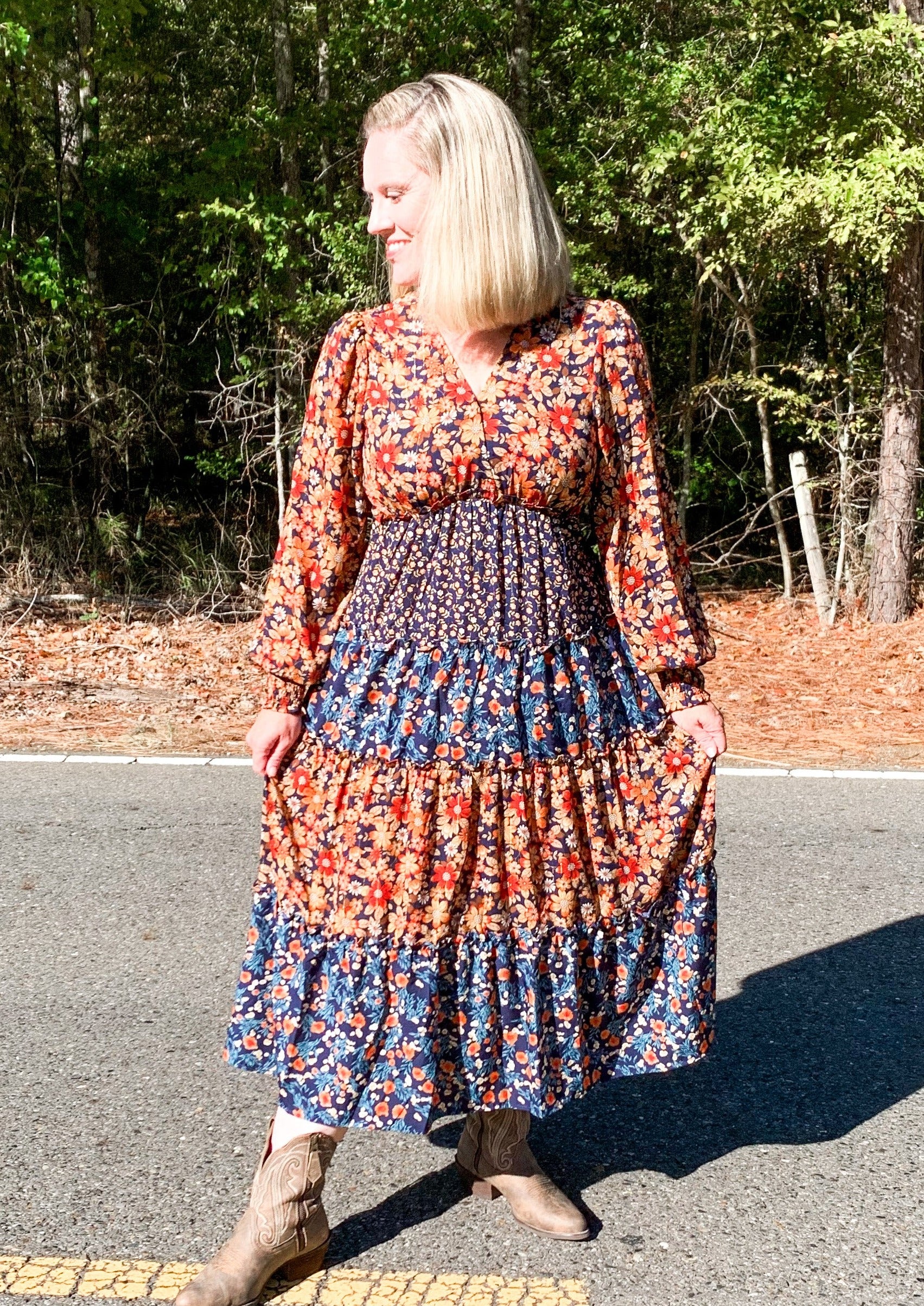 Tiered midi dress with mixed print tiers. It has a orange floral tier, a navy with small floral print tier, then a slightly lighter blue and orange printed tier.