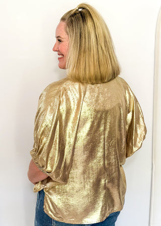 Shimmer Gold V-neck blouse with relaxed elastic short sleeves and a split hem at waist. 