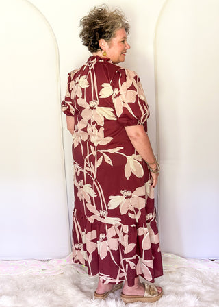 woman wearing tiered midi dress in Burgundy abstract floral print.