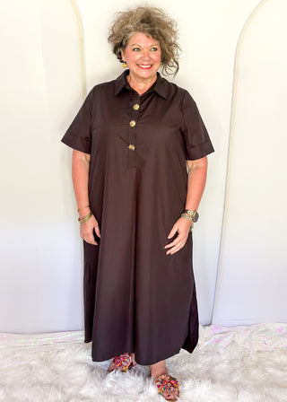 Casual black women’s dress with collared neckline, rolled sleeves, and decorative gold snaps