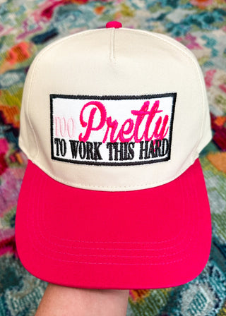 Snap-back canvas hat with hot pink bill.  Embroidered patch with "Too Pretty to work this Hard" in light pink, Hot pink, black. 