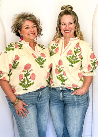 3/4 smocked sleeve cream top with large pink blooms. V-neck with pink trim detail. 