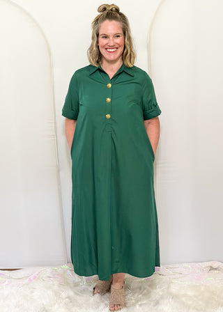 Woman wearing short sleeve, collared, Hunter Green midi dress with decorative gold snaps.