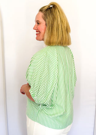 Striped seersucker top in green and white with short sleeves, relaxed fit, and split neckline.